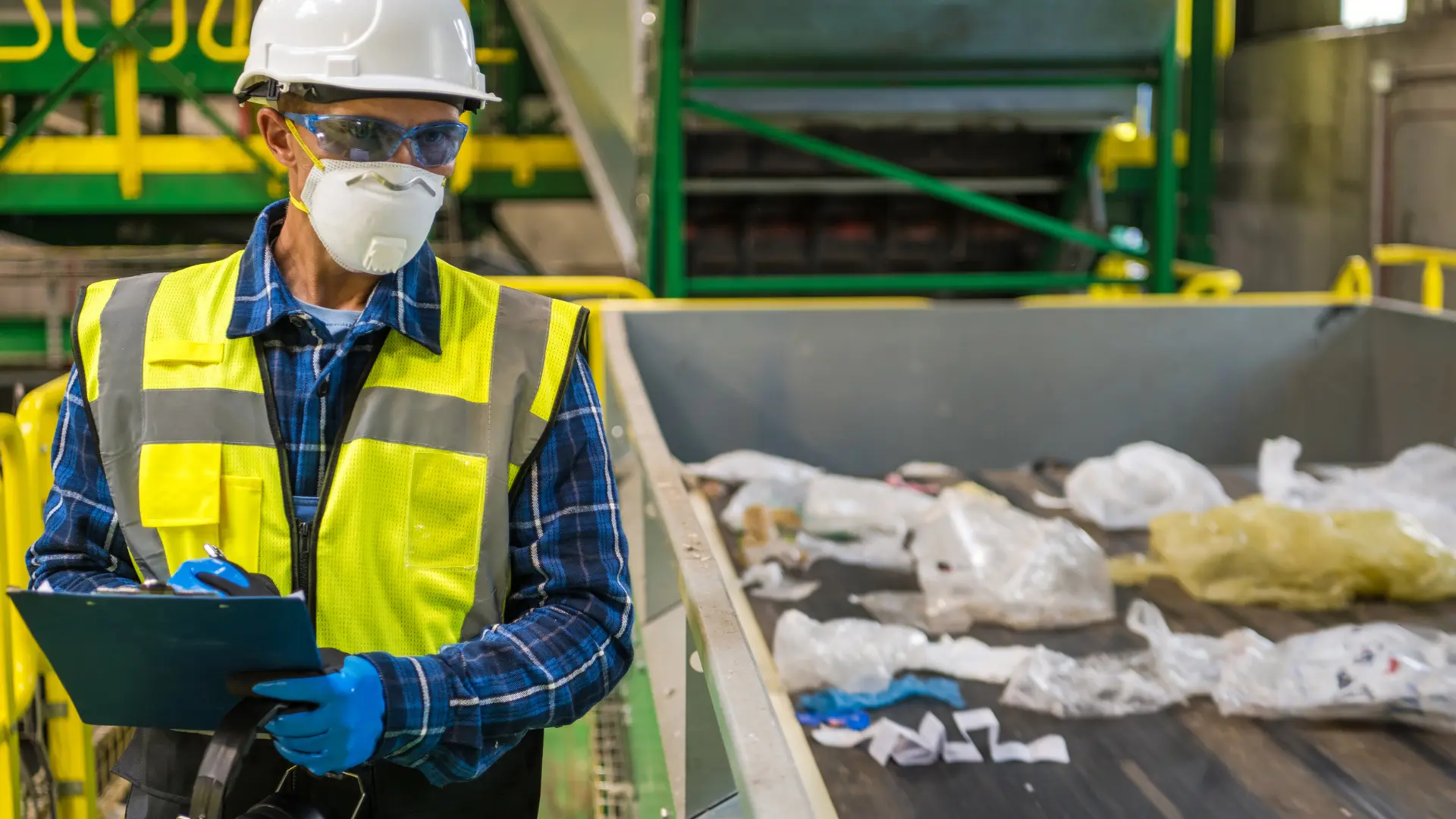 Política Nacional de Resíduos Sólidos. Trabalhador ao lado de reíduos prontos para serem reciclados.